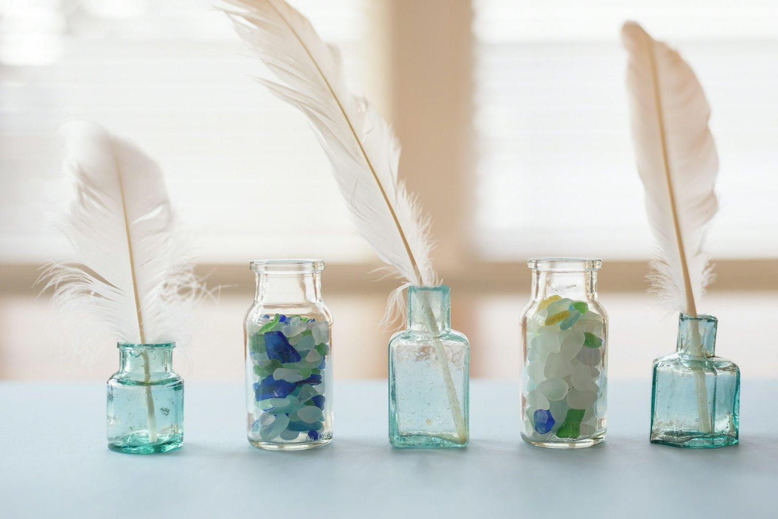 Vintage blue ink bottles filled with feather