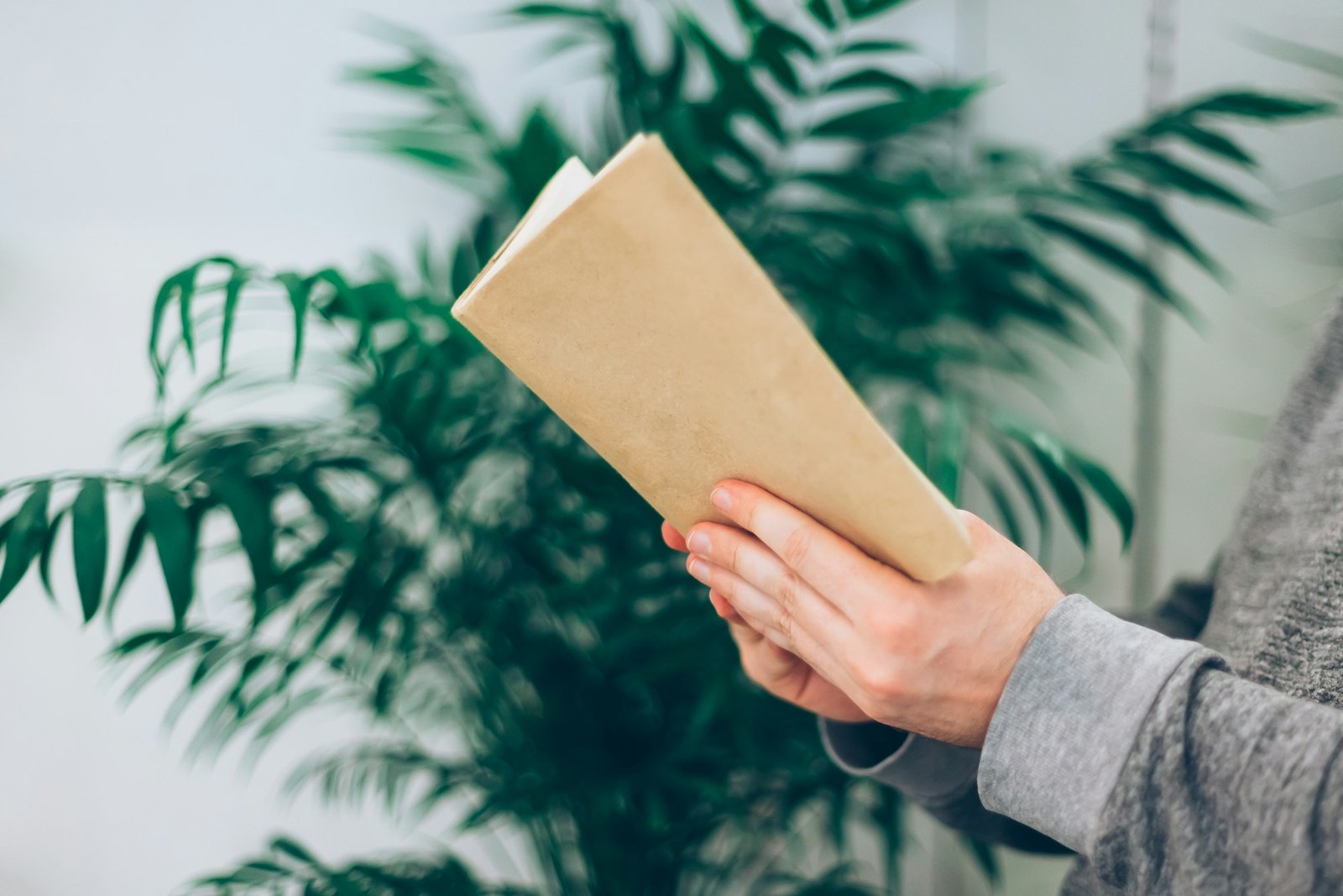 Young man reading open old paper book